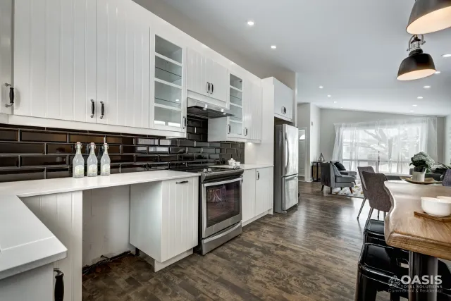 Completed kitchen improvement with white cabinets and dark tile backsplash