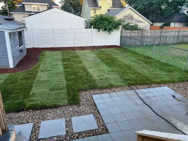 Kingscapes lawn renovation with gray pavers and gravel-bordered stepping stones