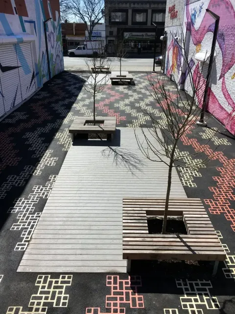 A row of wooden benches sitting next to each other on a sidewalk.