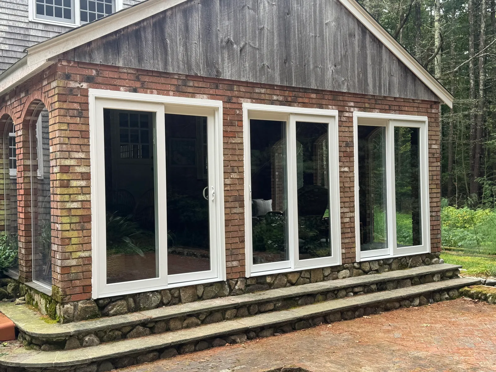 Historic home in Hingham featuring blue siding, double-hung windows, and a welcoming front entry with a porch, showcasing North Star-Bailey's exterior restoration services.