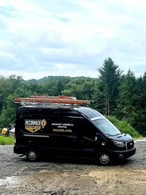 A McCormack Electric Van with a lovely green view in the background.
