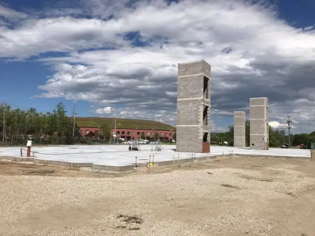 A large concrete structure is being built in the middle of a dirt field.