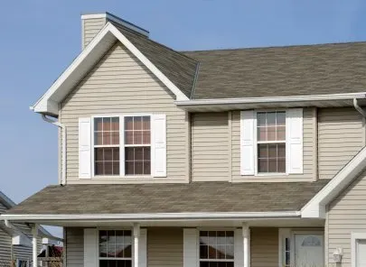 A house with a brown roof and white shutters