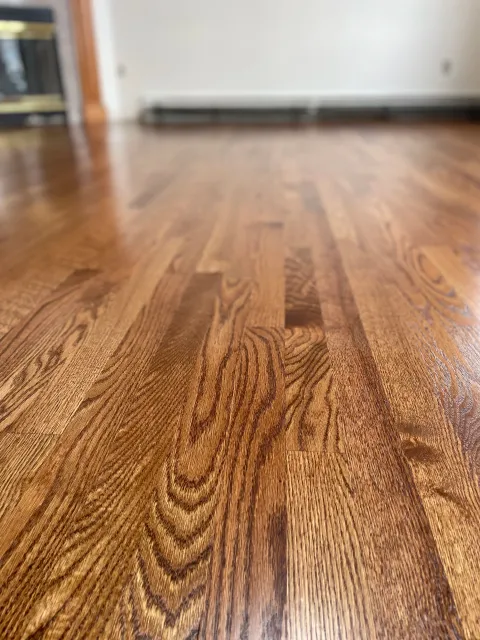Close-up of a polished wooden floor with a natural grain pattern.