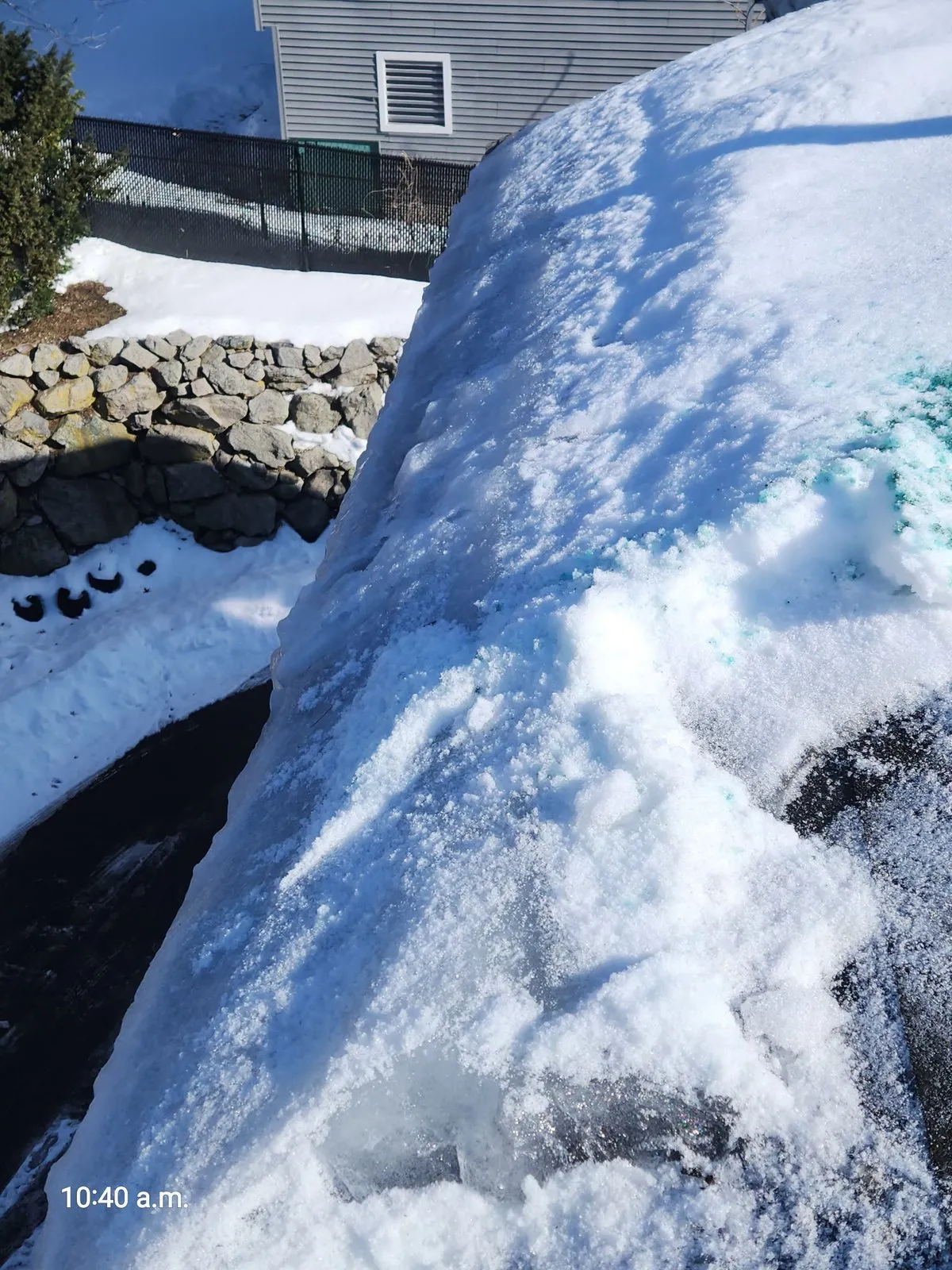 Steam ice dam removal in West Roxbury MA showing channel cut through accumulated ice without damaging shingles
