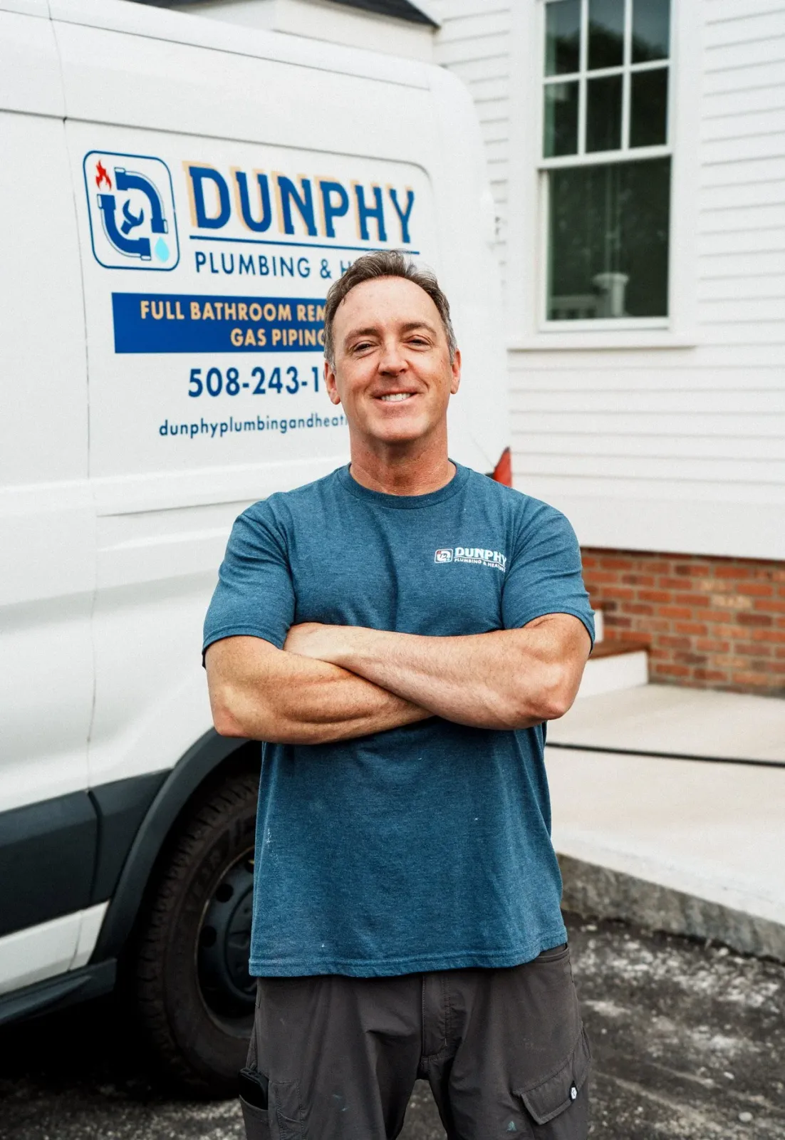 Bill Dunphy plumber on Cape Cod standing in front of van