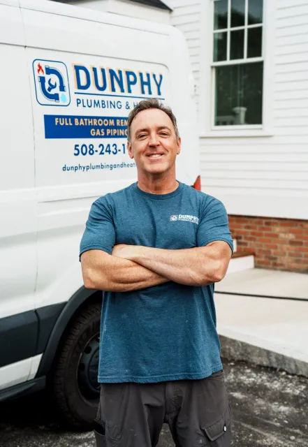 Bill Dunphy plumber on Cape Cod standing in front of van