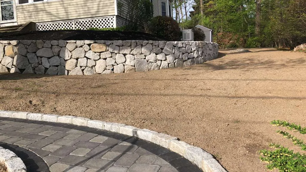 Stone wall with circular paver patio