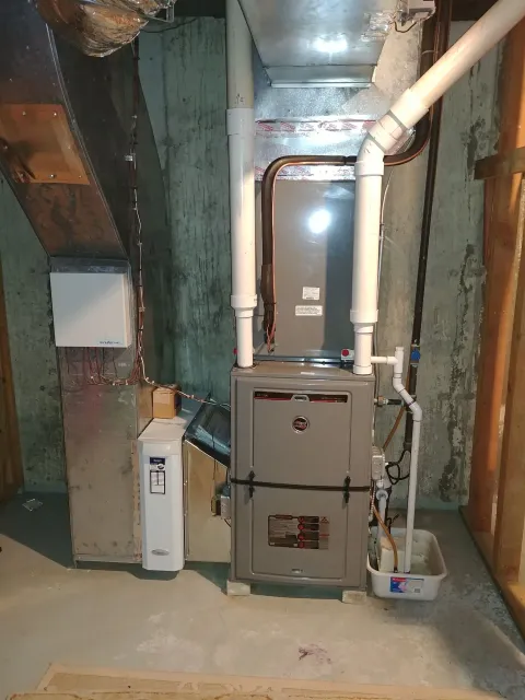 A basement with a furnace and a water heater.