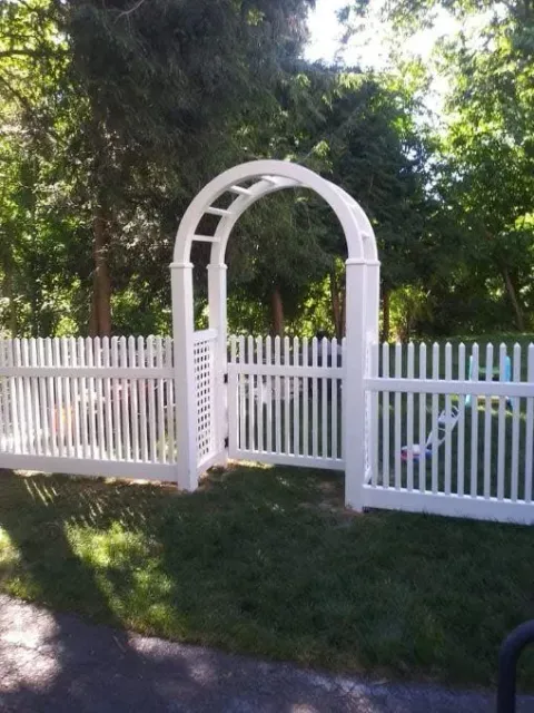 A person is painting a wooden fence with a brush.
