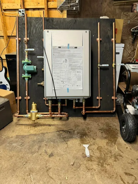 White wall-mounted boiler with copper pipes in a garage or basement setting