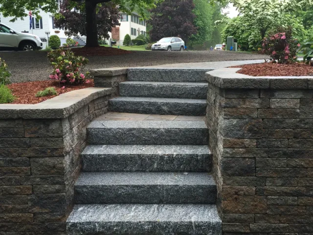 Granite steps set into a segmental block retaining wall
