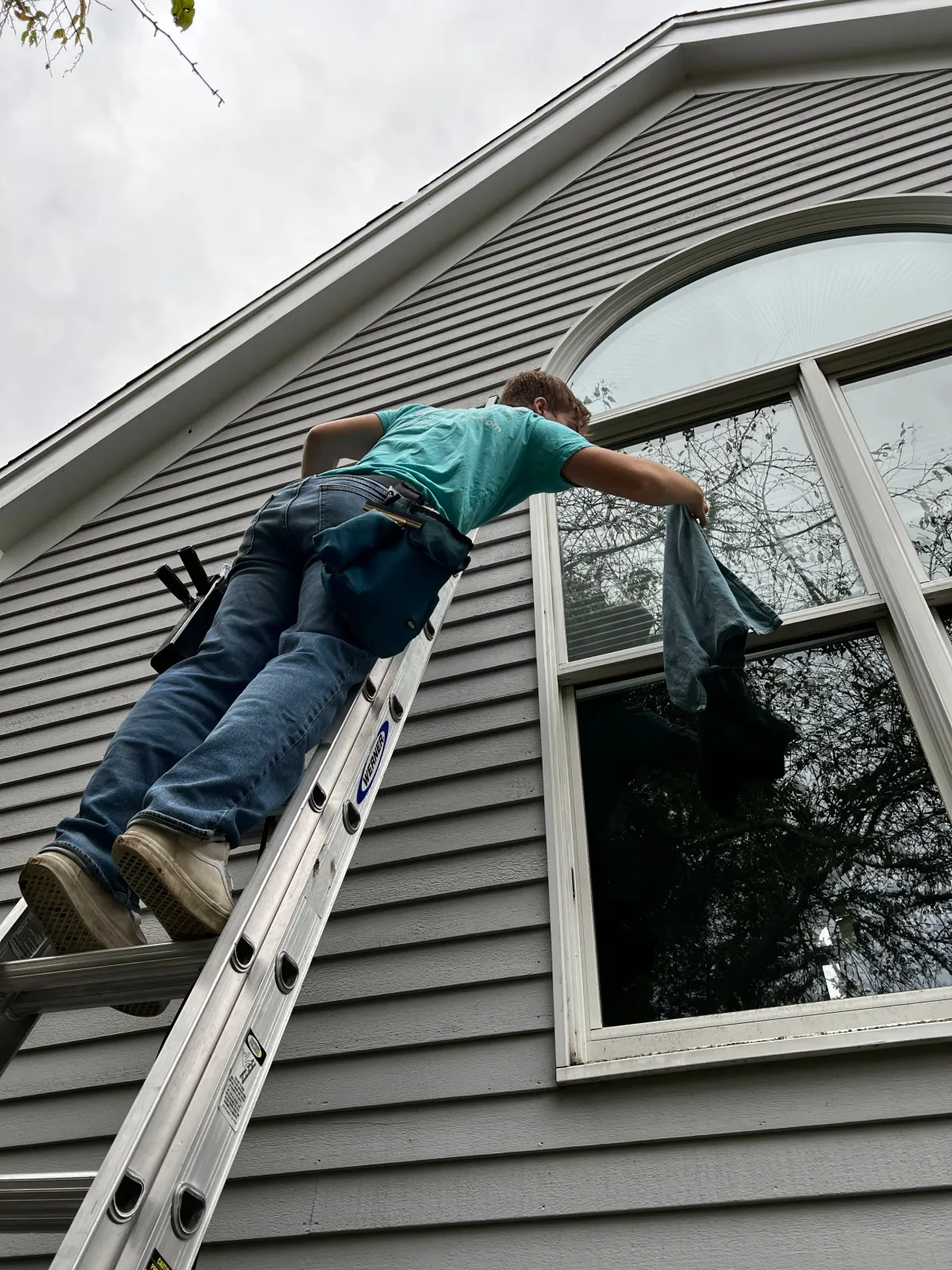 Person on ladder at large arched window