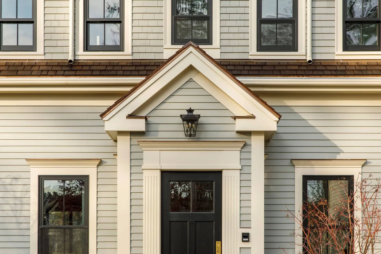 Home entry exterior with sage green panels and black windows