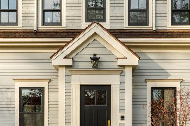 Home entry exterior with sage green panels and black windows