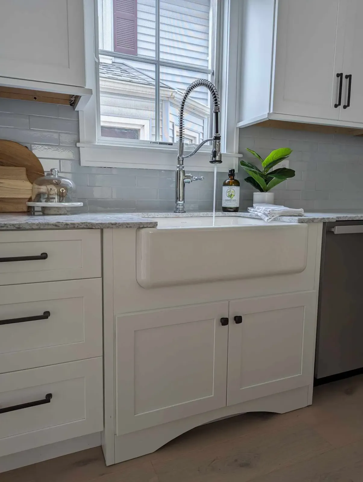 A kitchen with a white sink and a window.