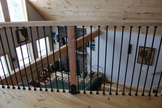 A wooden staircase with a wrought iron railing