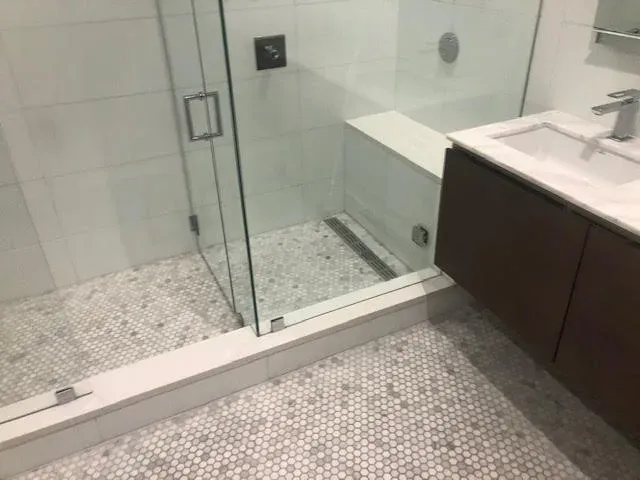 Completed bathroom renovation with tiled shower and vanity