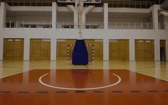Empty indoor basketball court with hoop