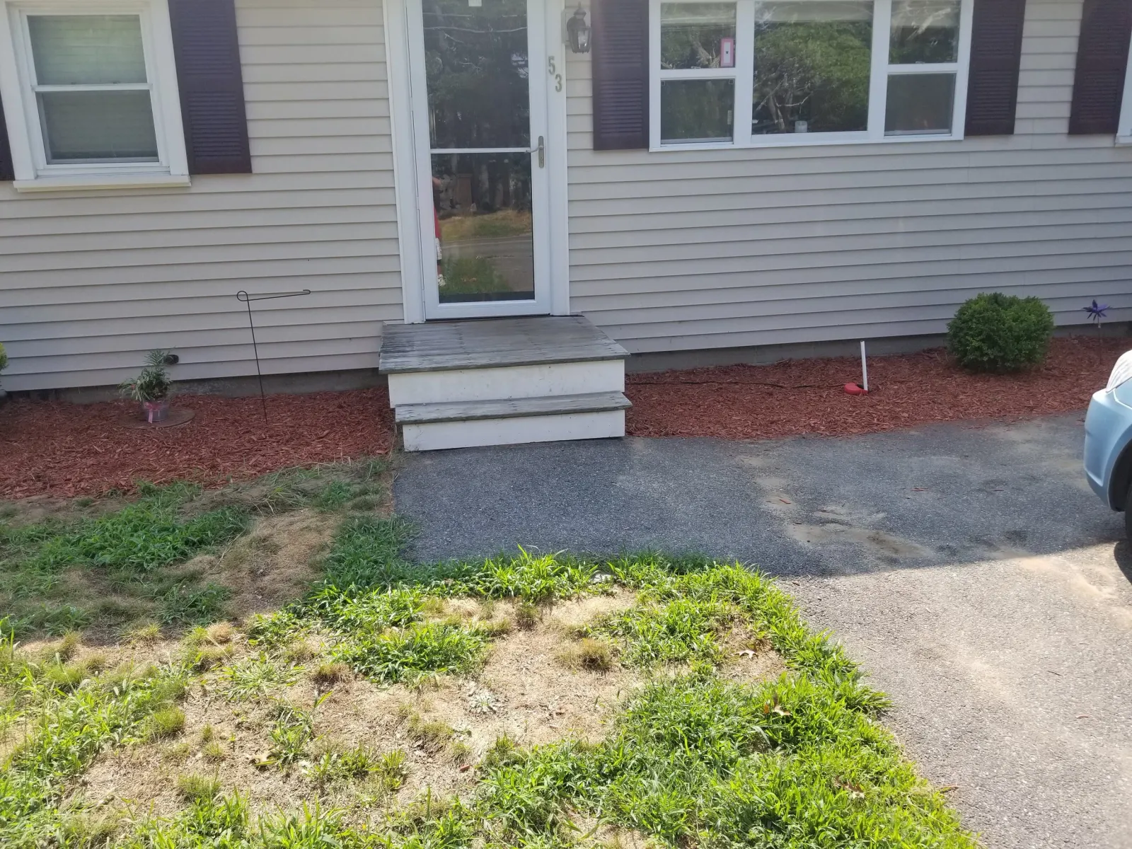 Before, the front door and step of a house, with no railing, and older looking wood.