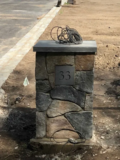 A stone pillar with a metal plaque reading