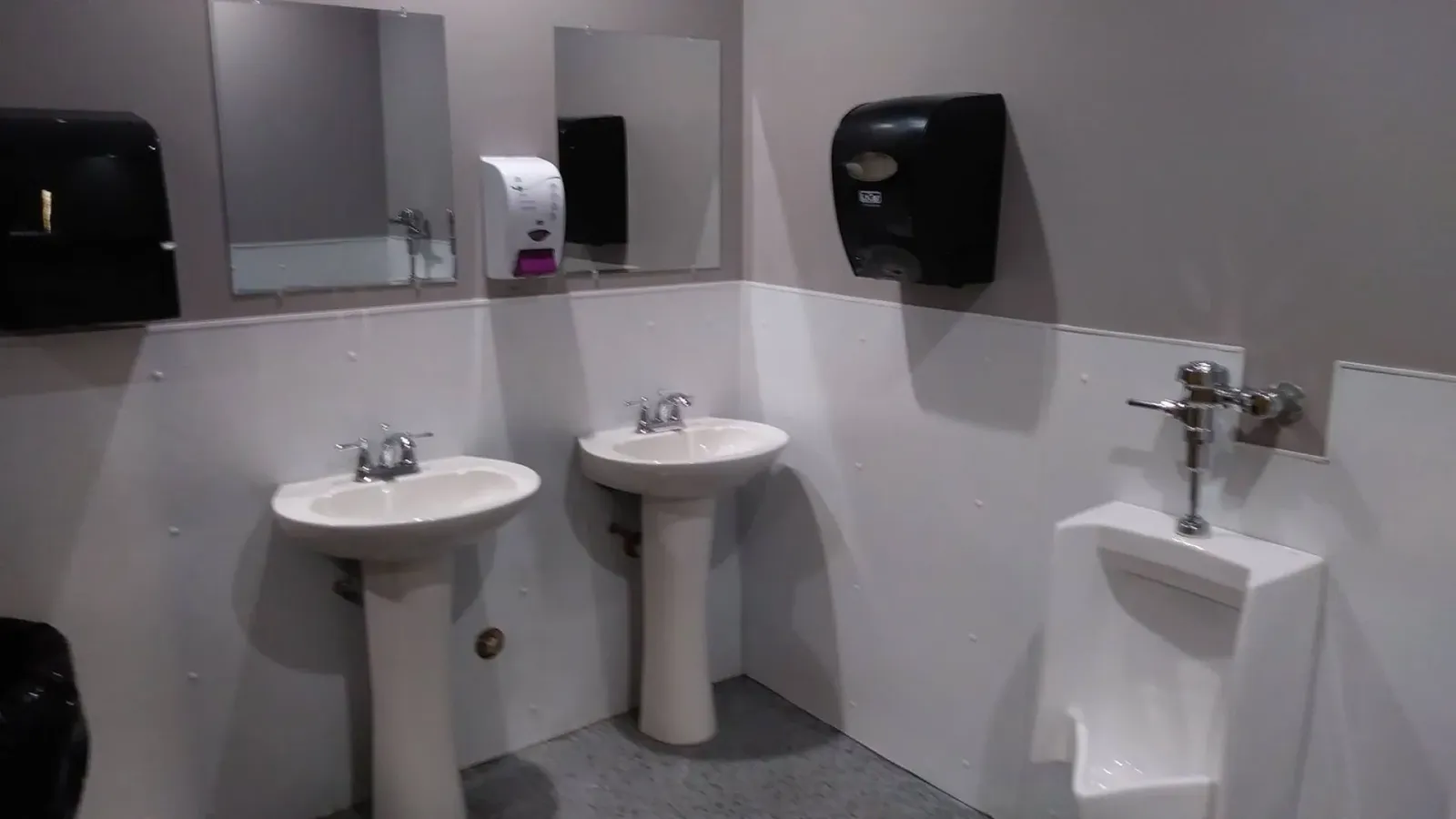 A bathroom with two sinks and a urinal.
