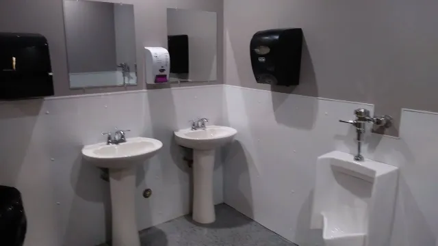 A bathroom with two sinks and a urinal.