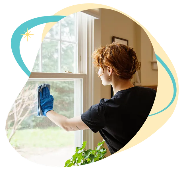 Belle Home cleaner wiping down a window