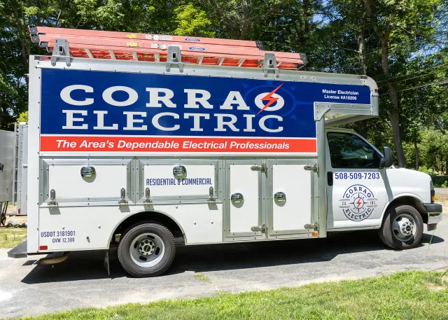 The corrao electric box truck with several ladders and doors, parked outside a clients home.