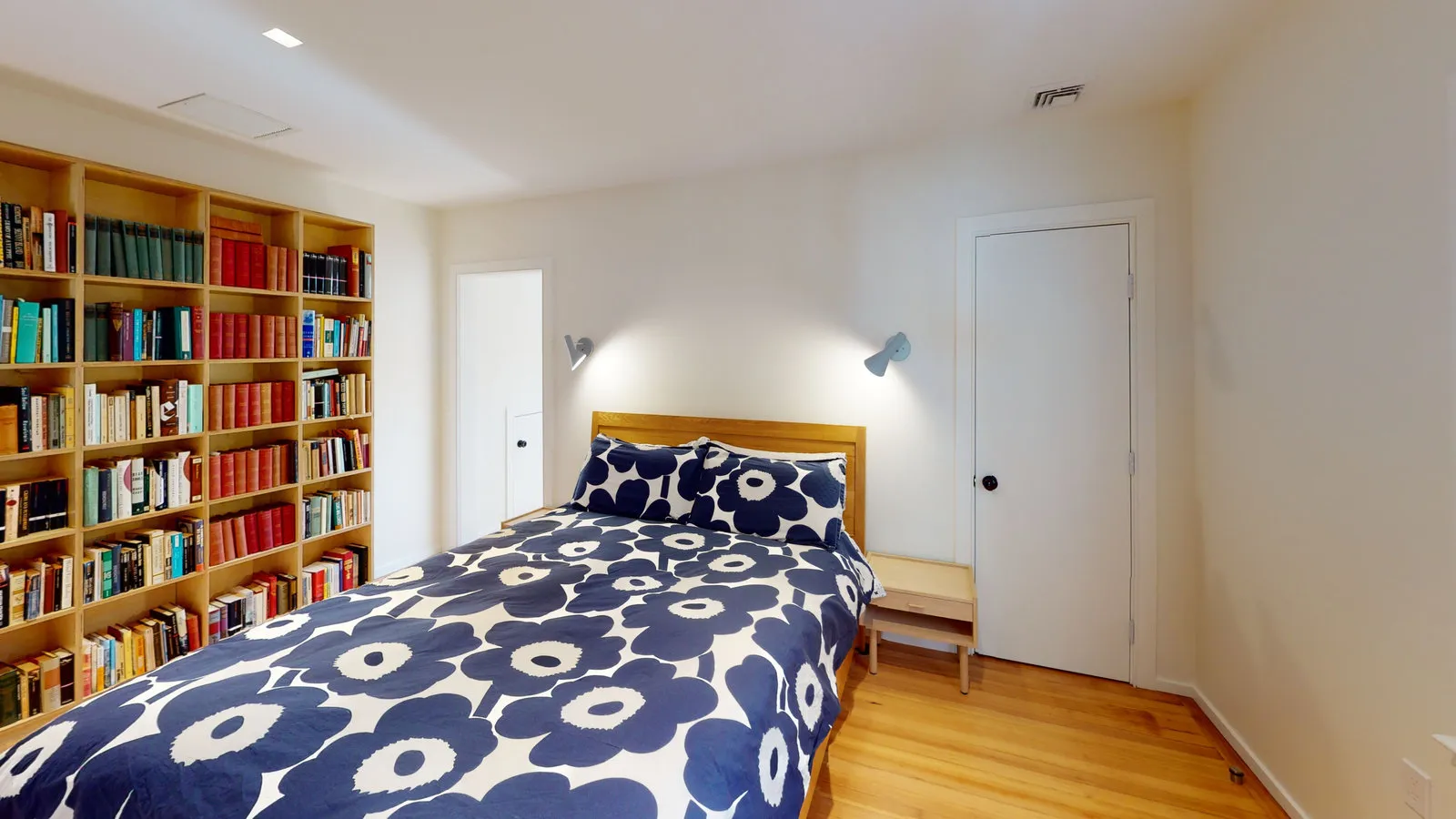 Bedroom with floor-to-ceiling built-in bookcase wall