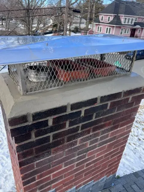 A brick chimney with a blue cover on top of it