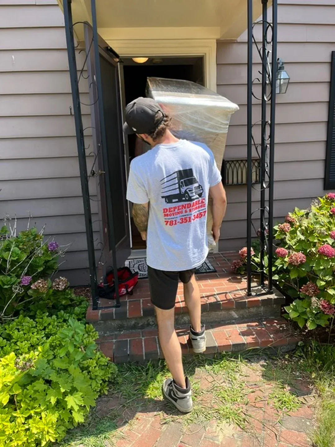 Depenable Moving worker bringing in furniture to a residential home, local moving services in norwell MA