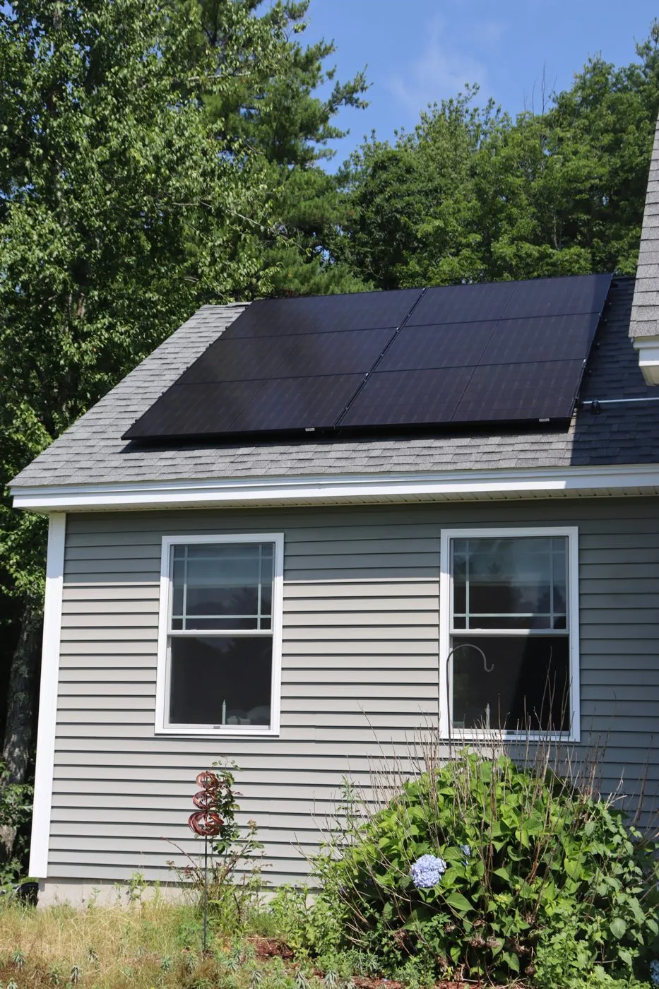 Close-up detail of black solar panels on an asphalt shingle roof