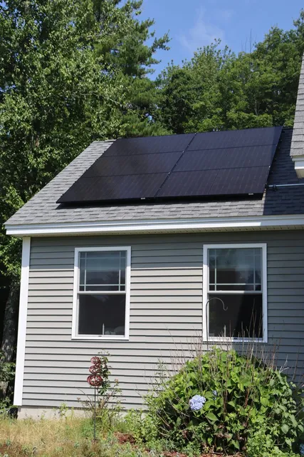 Close-up detail of black solar panels on an asphalt shingle roof