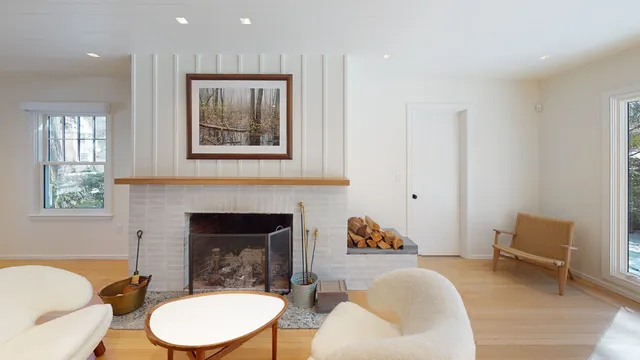 Living room with board-and-batten chimney breast and painted brick firebox