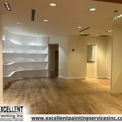 An empty room with hardwood floors and white shelves.