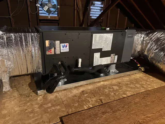 An air conditioner unit outside a house is being serviced with gauges and vacuum pump.