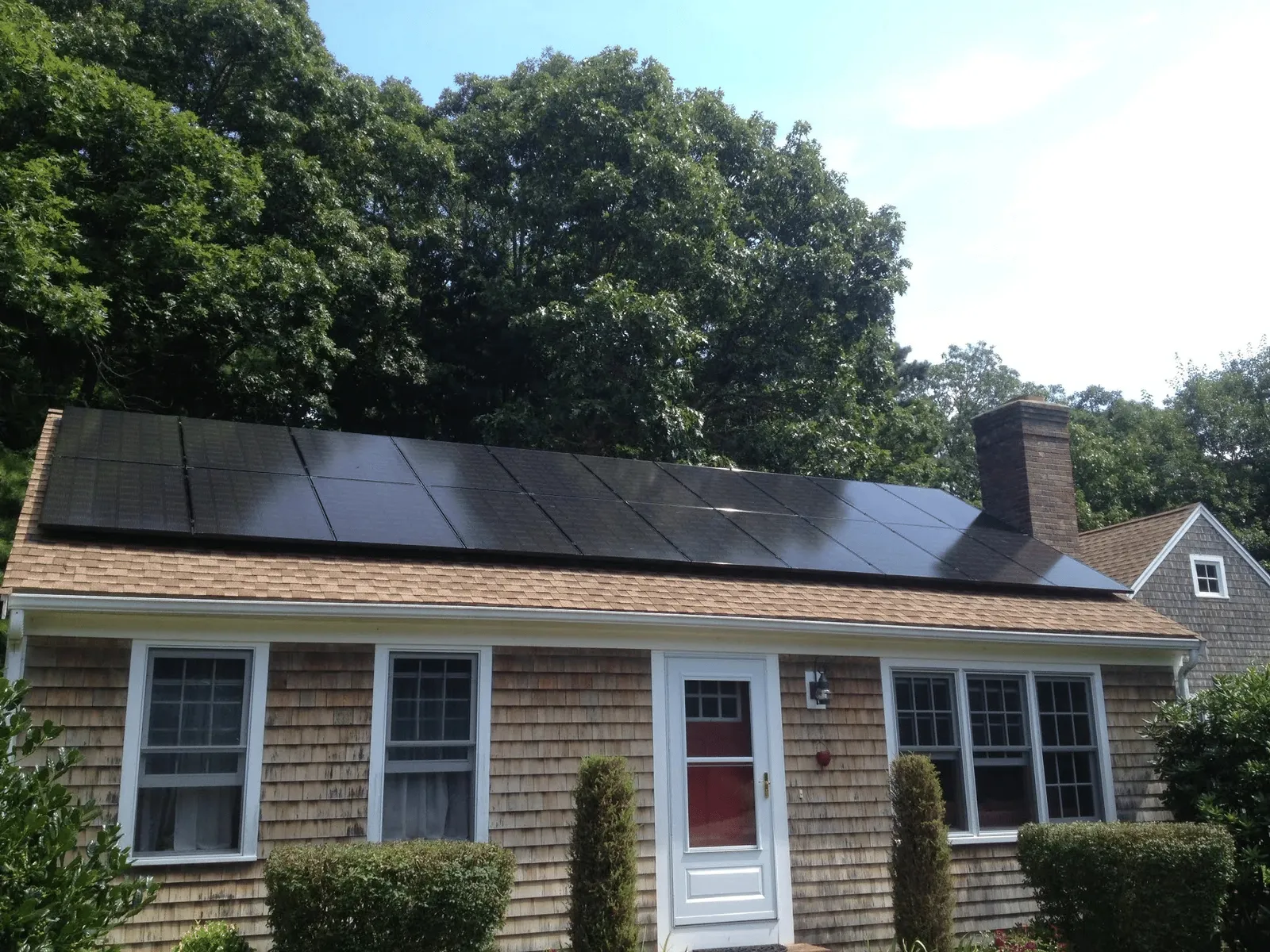 how with wood shingle siding with all black solar panels on roof