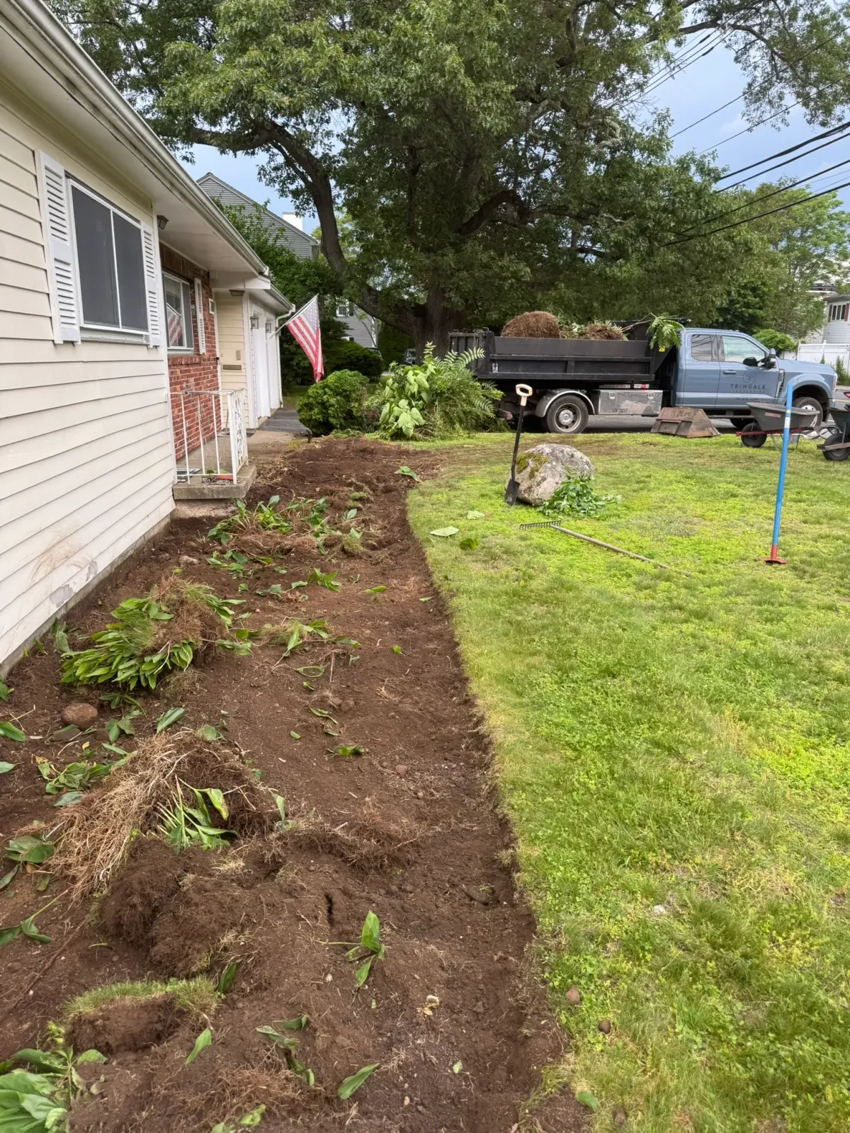 A tidy mulch bed running along a house foundation after a spring cleanup
