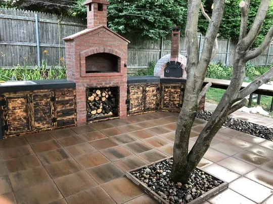 an outdoor patio with a brick BBQ