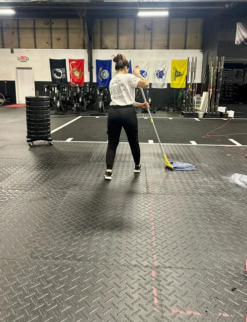 A Cupertino's team member mopping the floor of a fitness facility