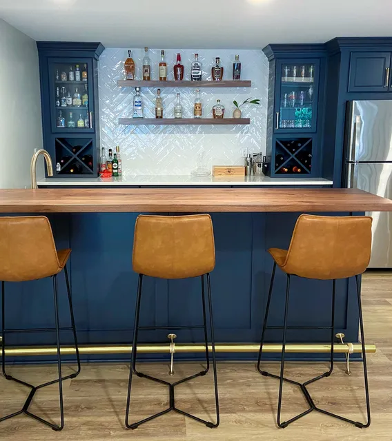 Haute Designs Kitchen & Bath. Bar. Designers Choice Cabinetry – painted navy blue. Cabinet features: wine storage, glass doors.