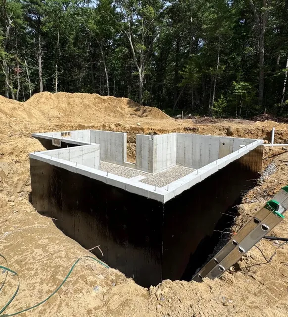 New foundation walls waterproofed with a black membrane before backfill
