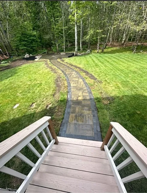 After: Stone paver path from deck through yard