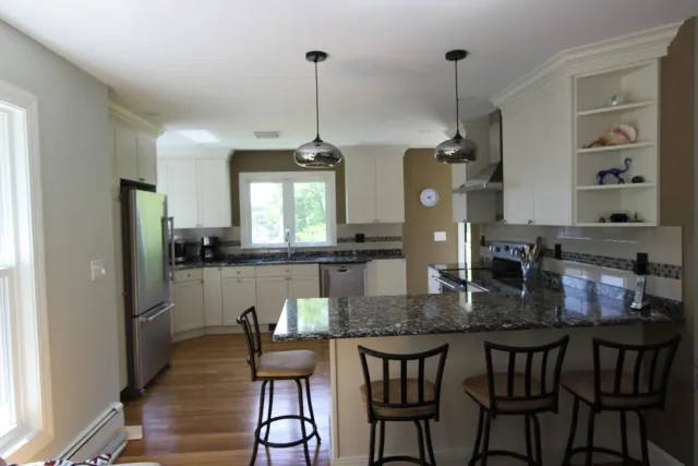 A kitchen with white cabinets and granite counter tops