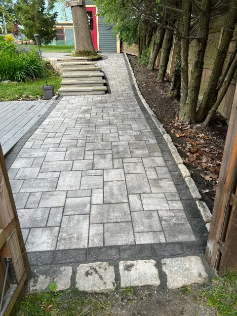 A brick walkway with stairs leading up to a house.