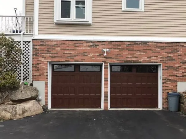 A brick house with two brown garage doors