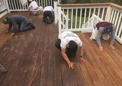 crew of workers refinishing a deck