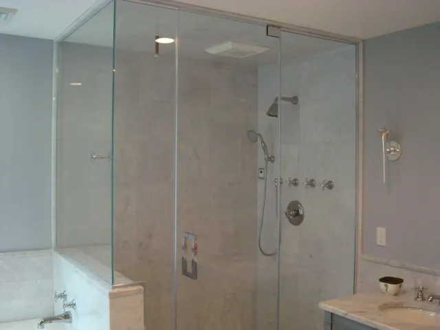 A bathroom with a walk in shower and a sink.