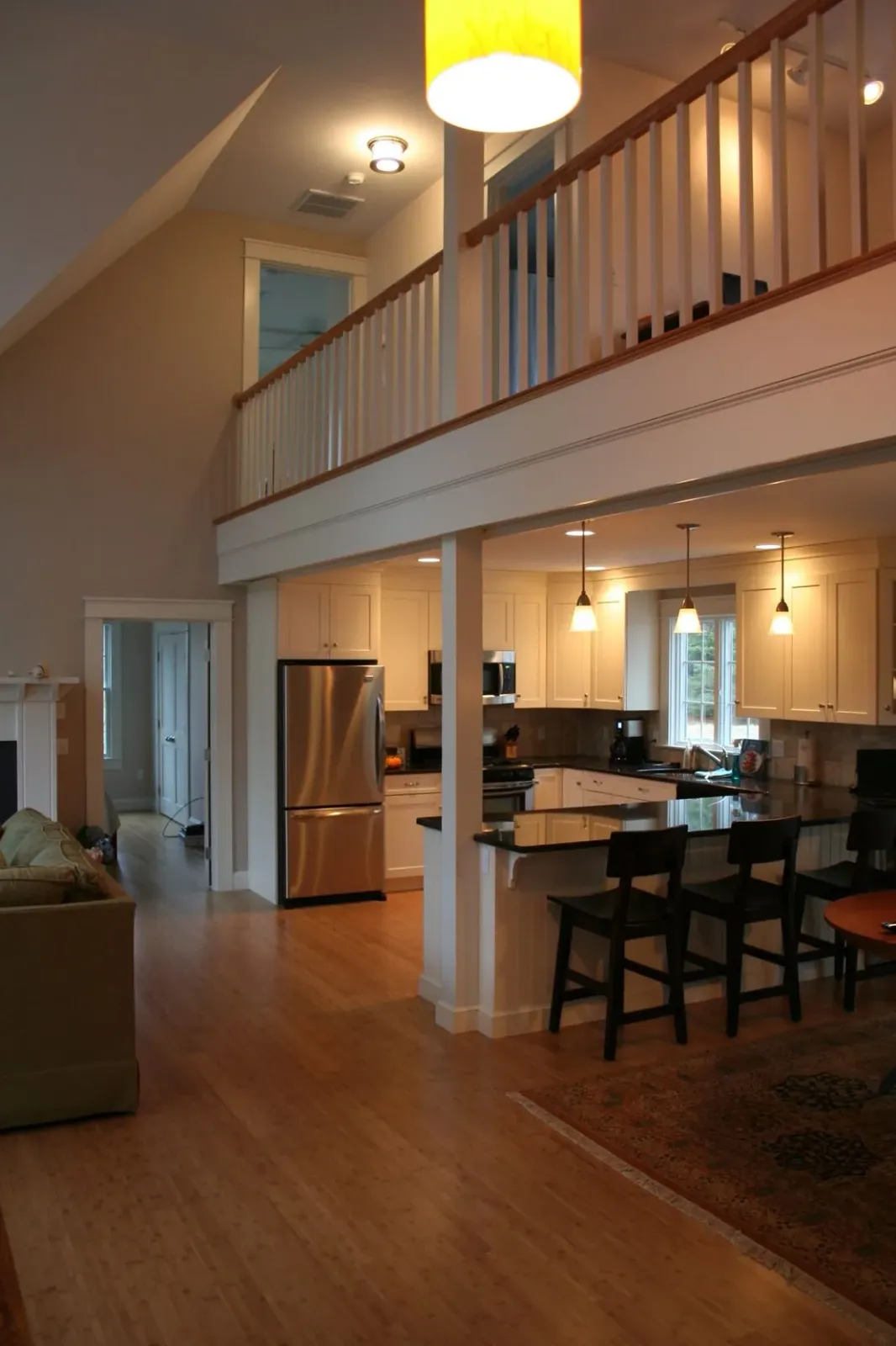 Spacious open-concept home with a kitchen, dining area, and loft. Light wood floors and white walls, stainless steel appliances